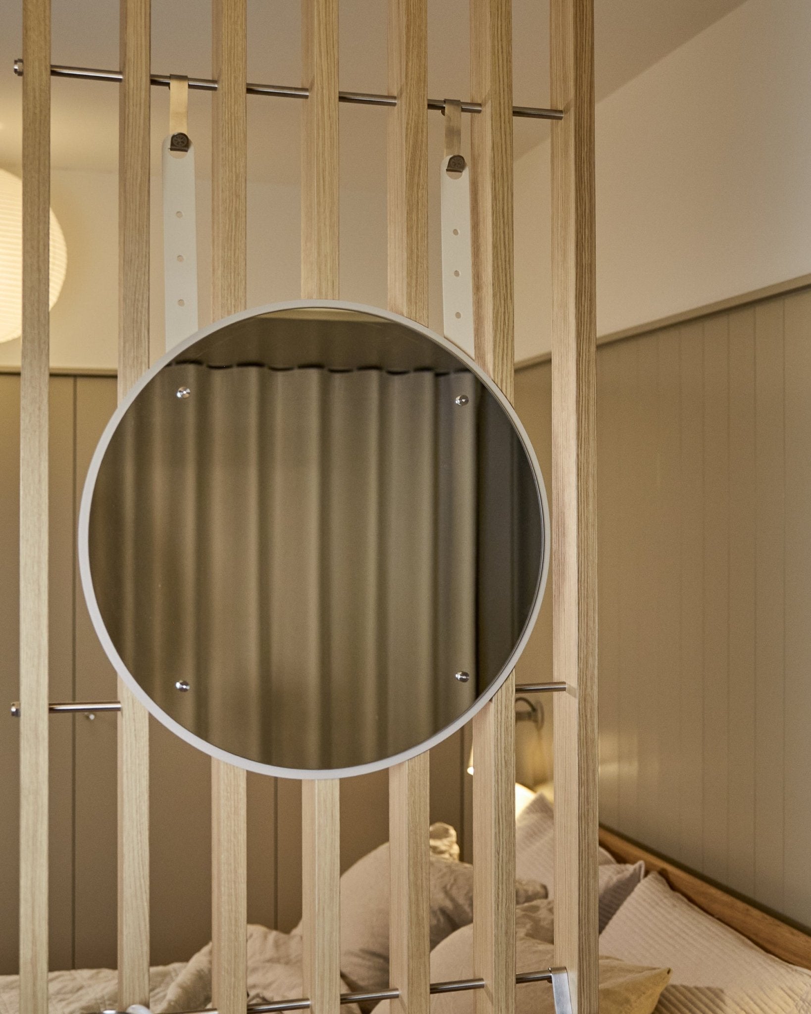 Round, height-adjustable Vala BM1 mirror by WoodUpp, 54 cm diameter, mounted on vertical acoustic wood slat panel with soft neutral lighting.